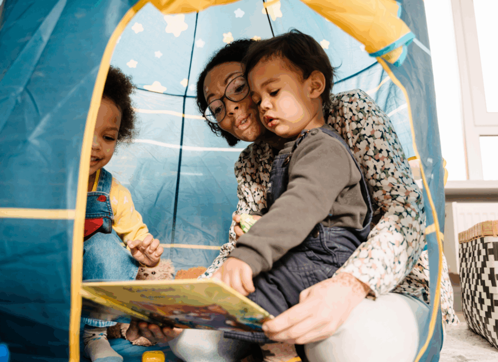 Mother reading with toddlers during learning through play time